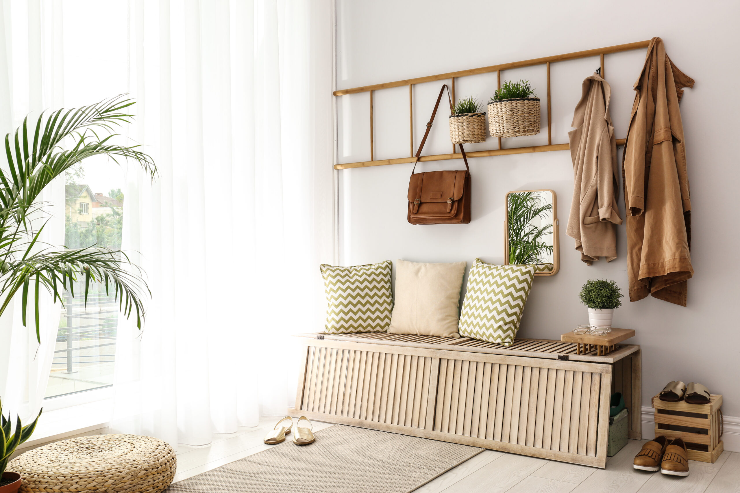 an entryway with a wooden storage bench and hangers