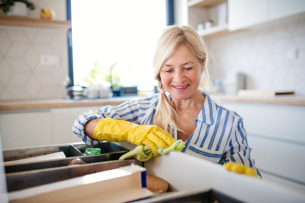 A woman cleaning a kitchen drawer