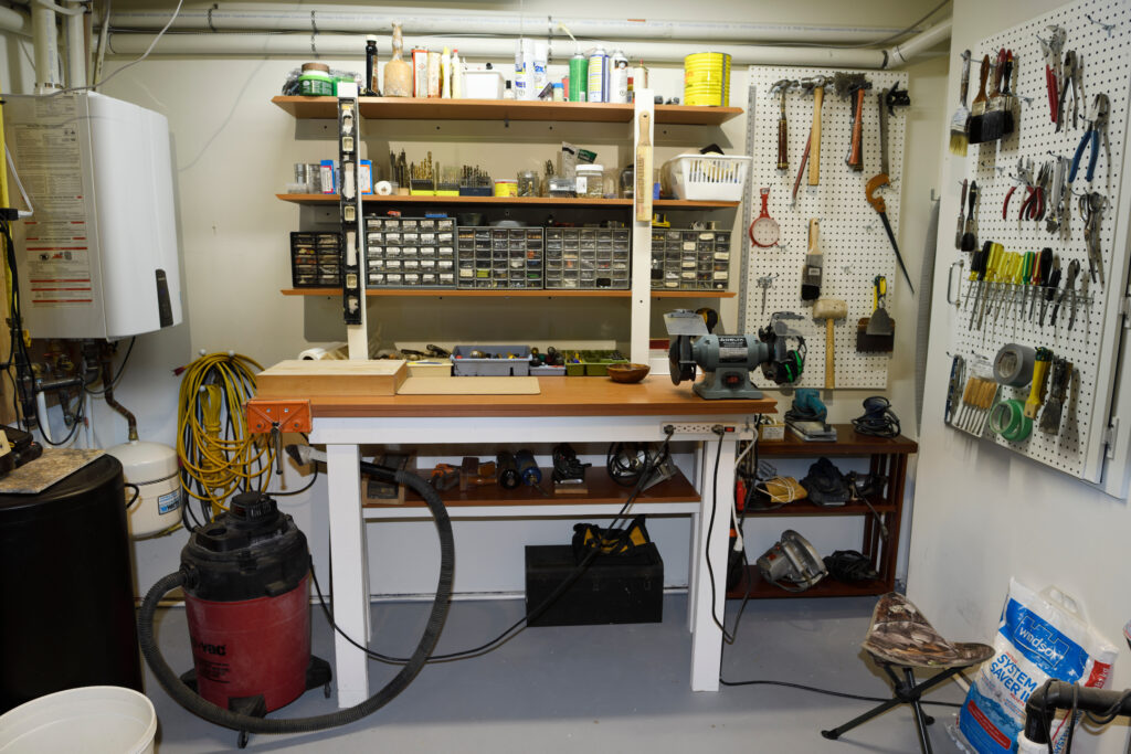 a workbench and pegboards as part of a basement workshop