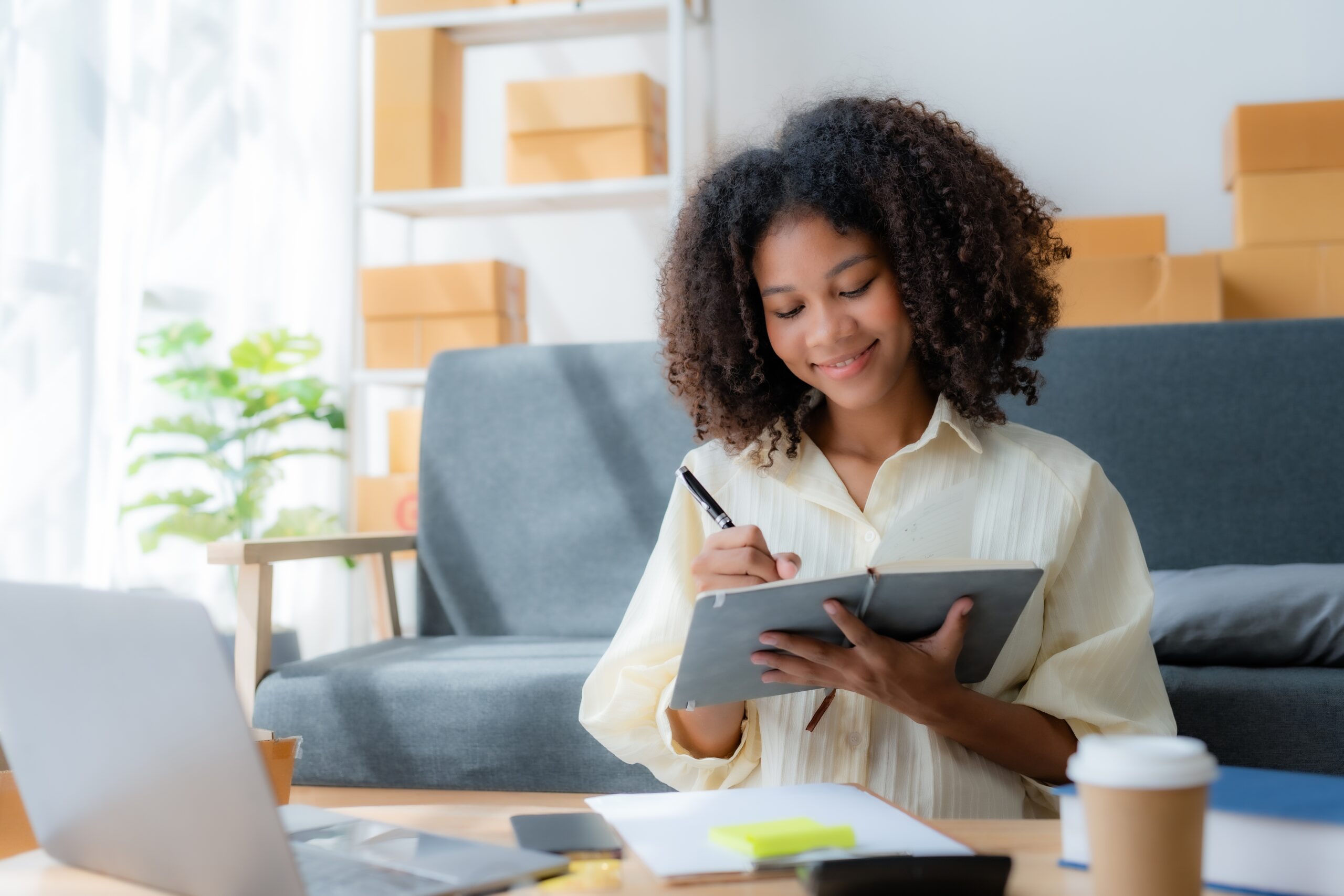 A woman taking inventory of her items with cardboard boxes in the background