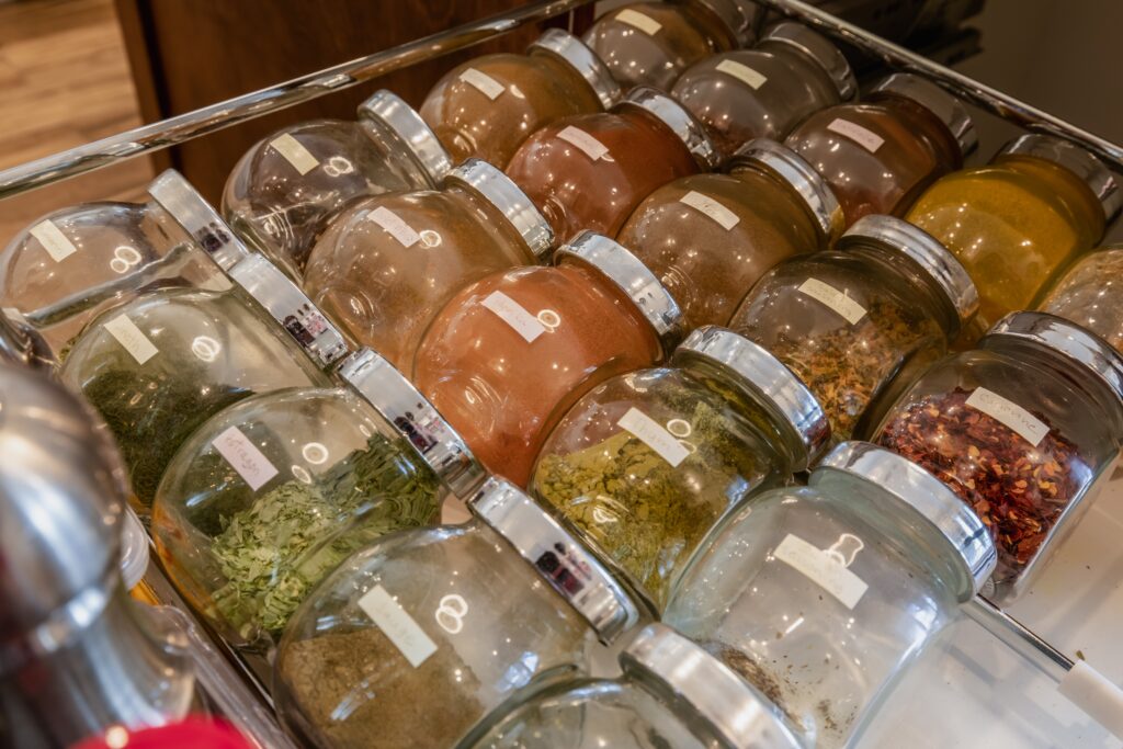 open drawer with rows of spices in labeled glass jar