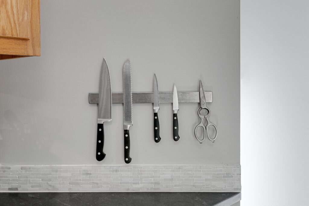 A magnetic strip with some metal knives and metal scissors