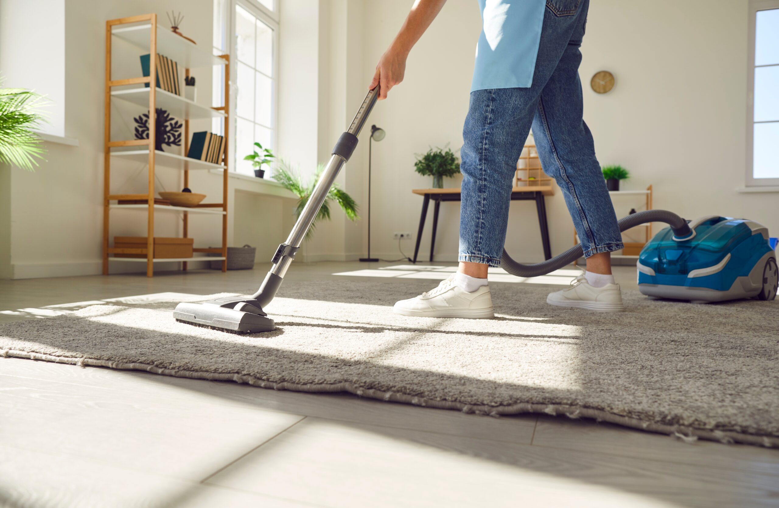 A person vacuuming carpets at home