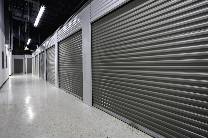 Image of indoor climate-controlled storage units, dark rollup doors, well lit hallways